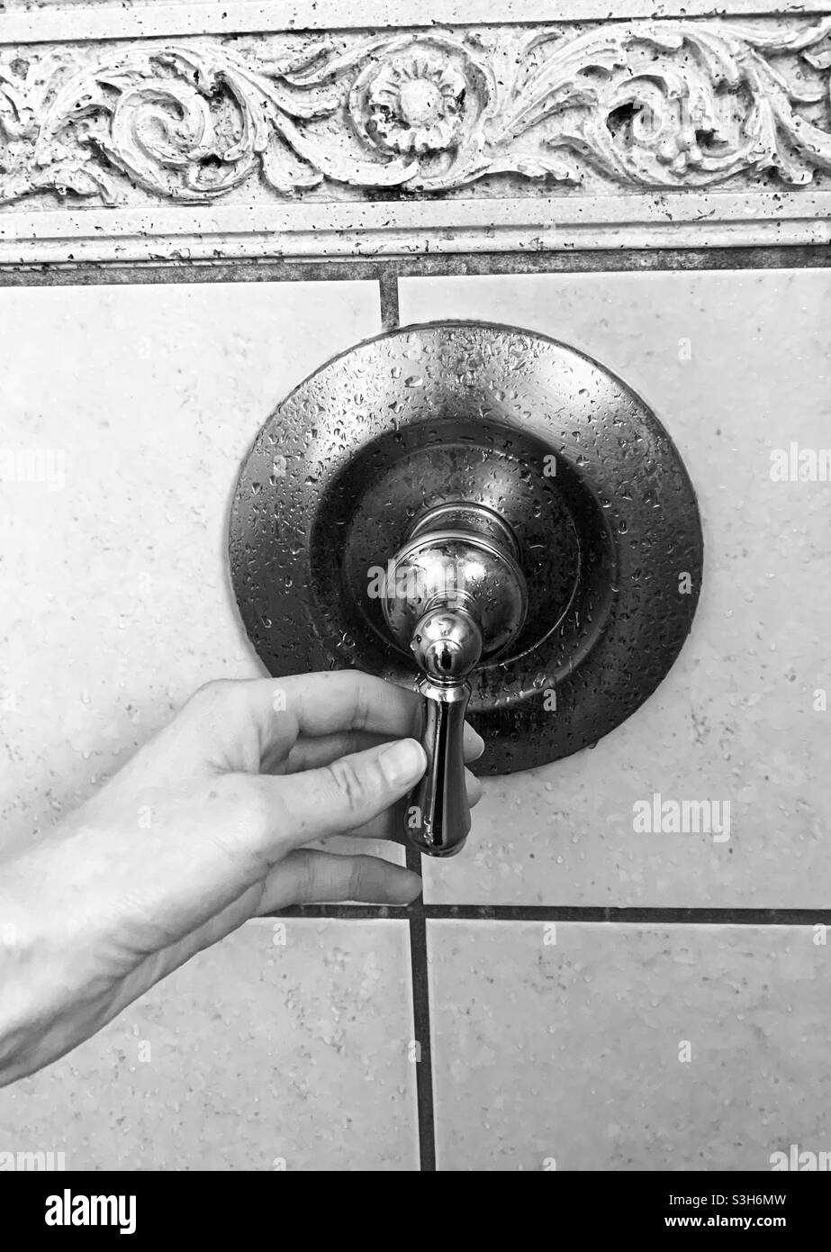 Woman turning the shower handle on to take a shower in the bathroom Stock Photo Alamy