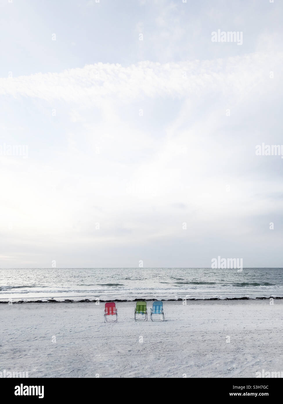 Three beach chairs on beach Stock Photo