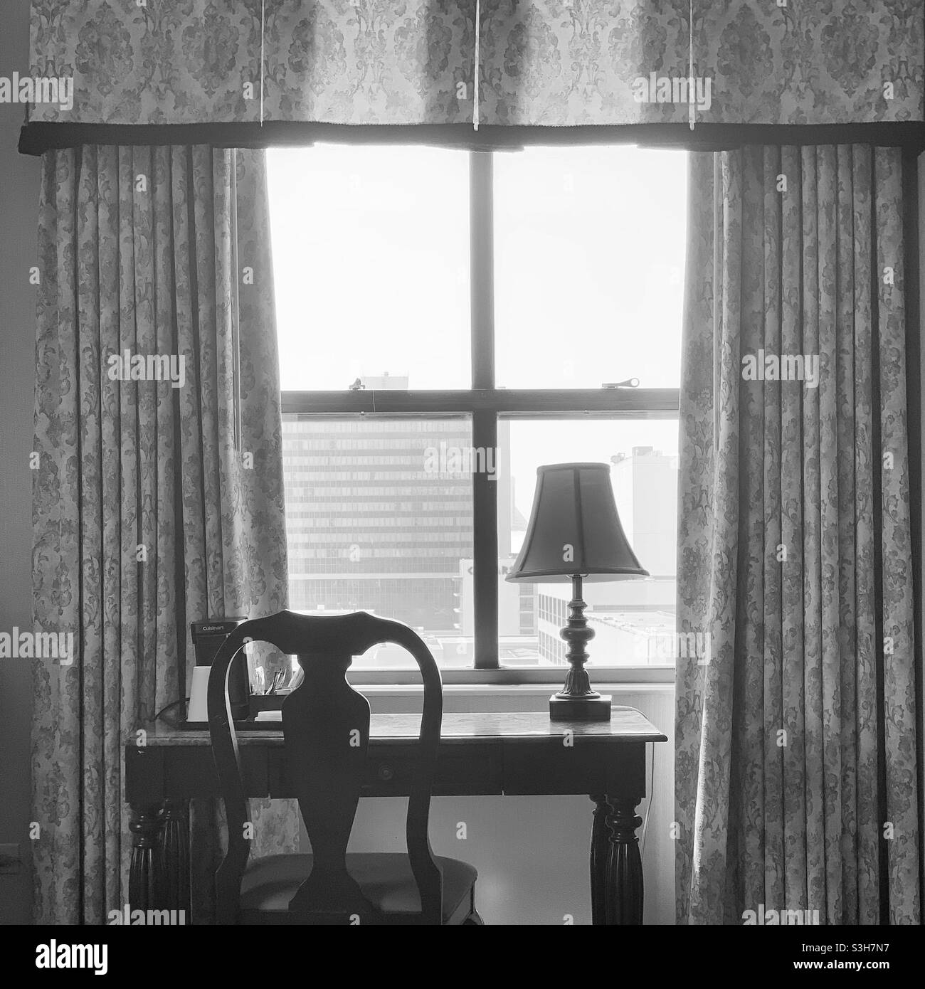 Black and white image of a desk facing a window in a guestroom at the Claridge Radisson Hotel, Atlantic City, New Jersey, United States - Smartphone Captured Stock Image