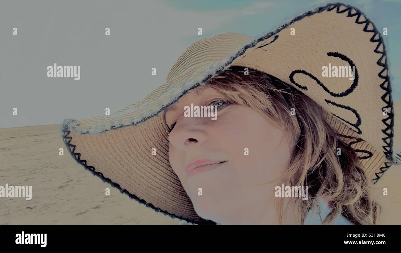 Washed out image woman in beach hat Stock Photo