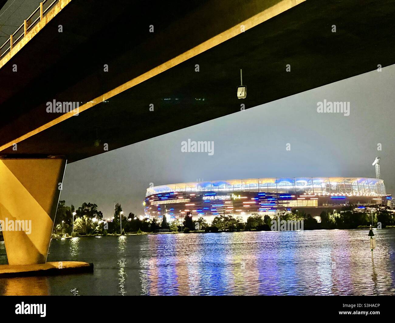 Windan Bridge over the Swan River looking at Optus Stadium lit up in West Coast Eagles colours at night Perth Western Australia. Stock Photo