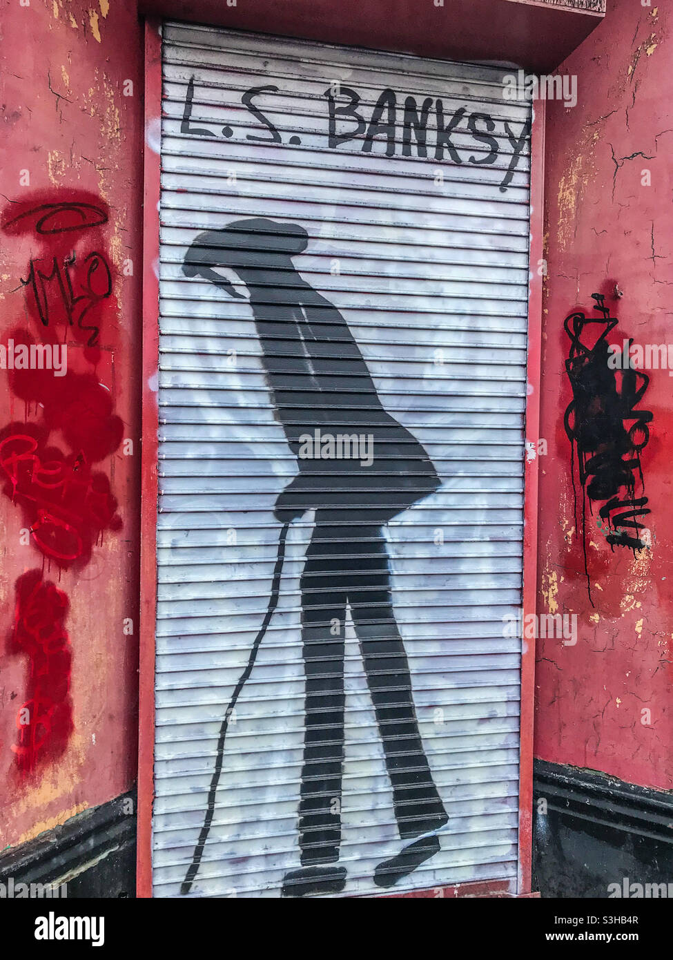 L. S. Lowry street art on a shop shutter - Smartphone Captured Stock Image