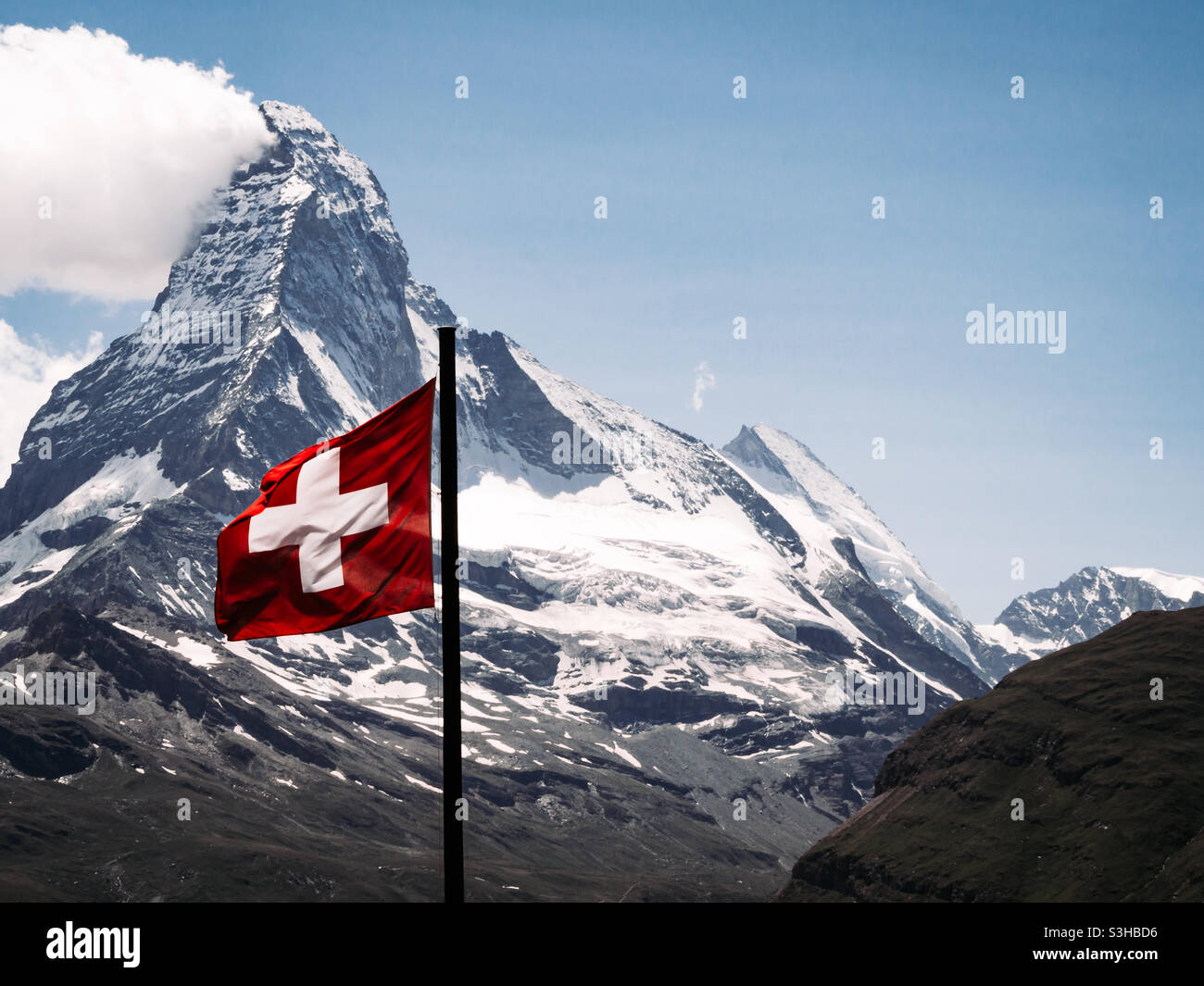 Matterhorn mountain with Swiss flag in soft wind Stock Photo