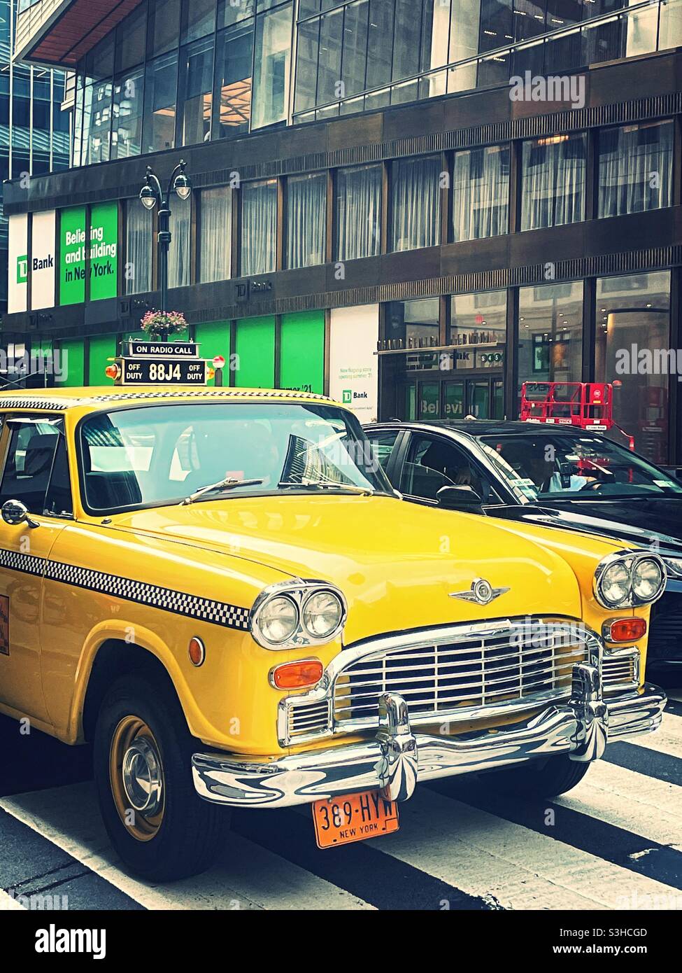 A vintage checker yellow taxi cab parked on the new York city Street