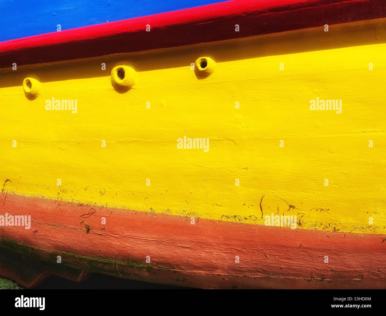 Sunlit detail of a brightly painted boat moored in a Cornish harbour, August. - Smartphone Captured Stock Image