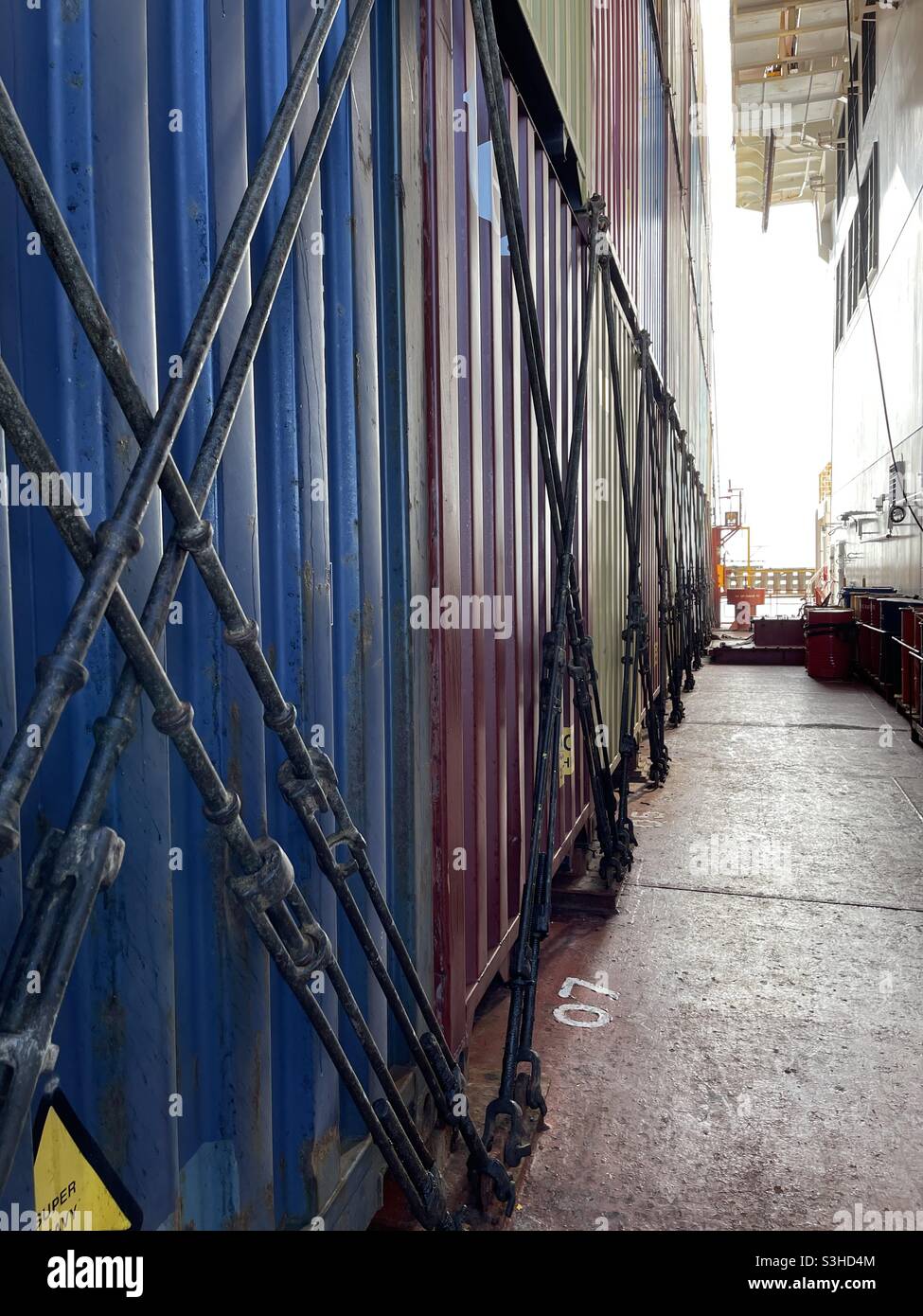 Stowed  containers.on main deck behind superstructure and lashed with bottom and semiautomatic twist locks and lashing bars on merchant container vessel. Stock Photo