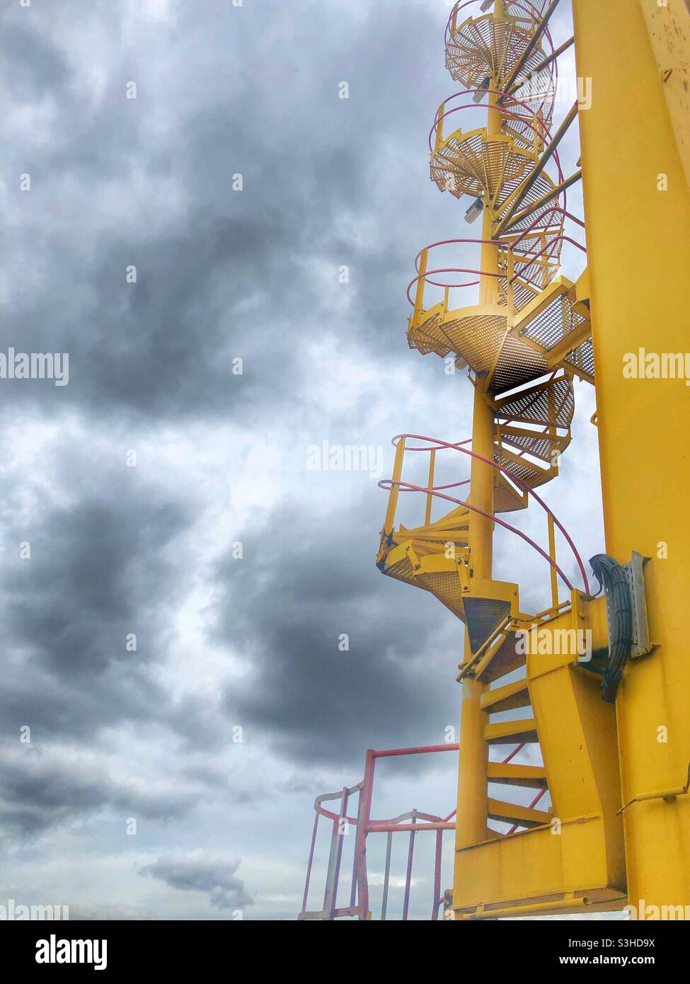 A low angle view of a spiral staircase leading up to a dark and dramatic cloudy sky - Smartphone Captured Stock Image A low angle view of a spiral staircase leading up to a dark and dramatic cloudy sky - Smartphone Captured Stock Image