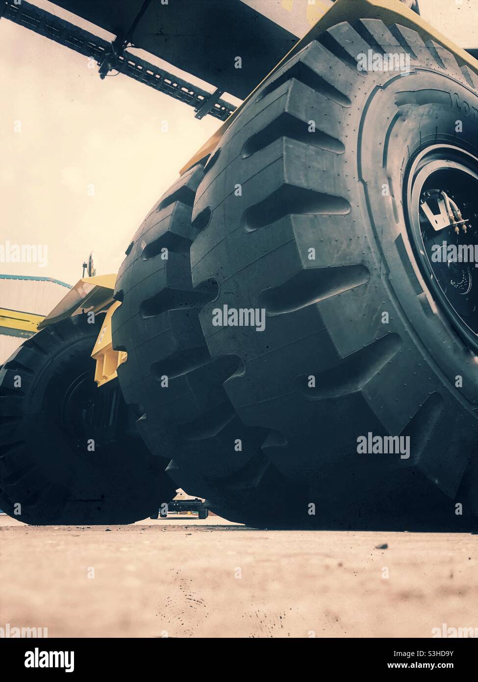 Low angle view of the large industrial tyres of heavy plant machinery - Smartphone Captured Stock Image