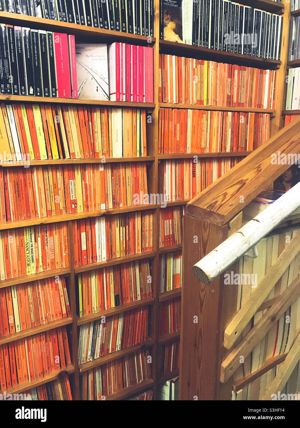 Orange spine penguin books in second hand book shop - Smartphone Captured Stock Image