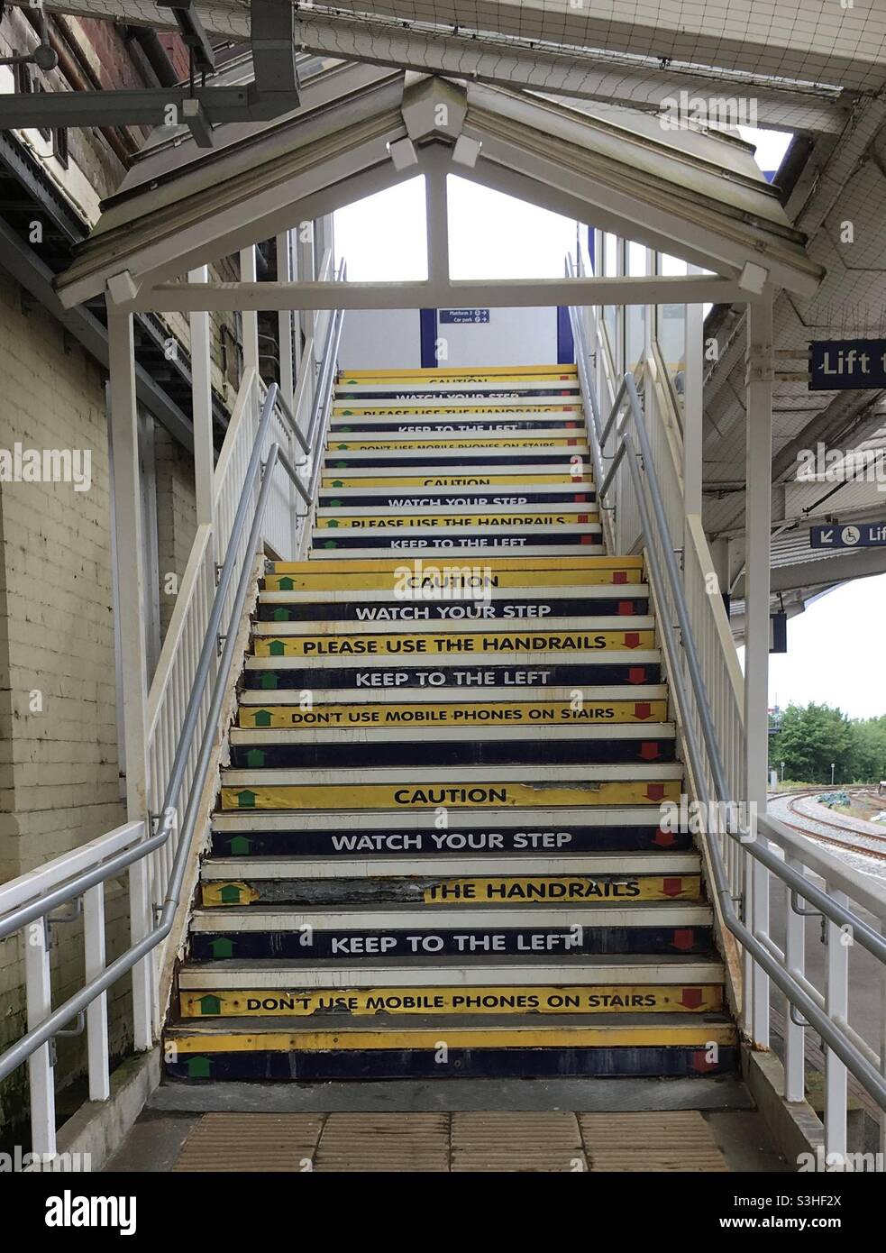 Wooden stairs to the footbridge over railway lines at Harrogate Rail Station, North Yorkshire, UK.Opened in 1862, this was largely rebuilt in 1964-5.Trains go to Leeds, London, York and elsewhere. Stock Photo