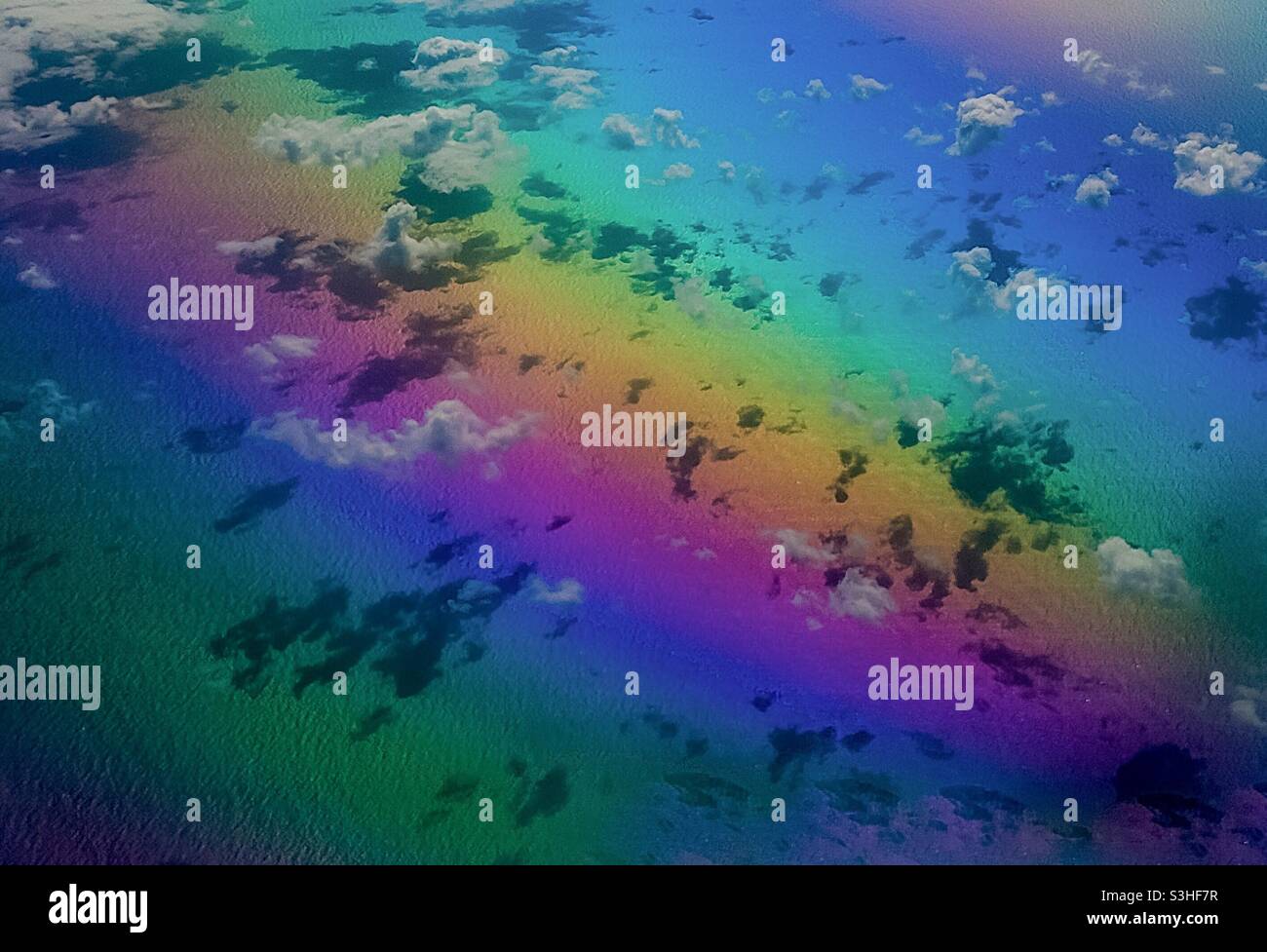 Rainbow colours beneath the clouds, aerial at 10000 meters. Concepts: floating free, rainbows, Joy, abandon, light spectrum, dreamlike, refraction - Smartphone Captured Stock Image Rainbow colours beneath the clouds, aerial at 10000 meters. Concepts: floating free, rainbows, Joy, abandon, light spectrum, dreamlike, refraction - Smartphone Captured Stock Image