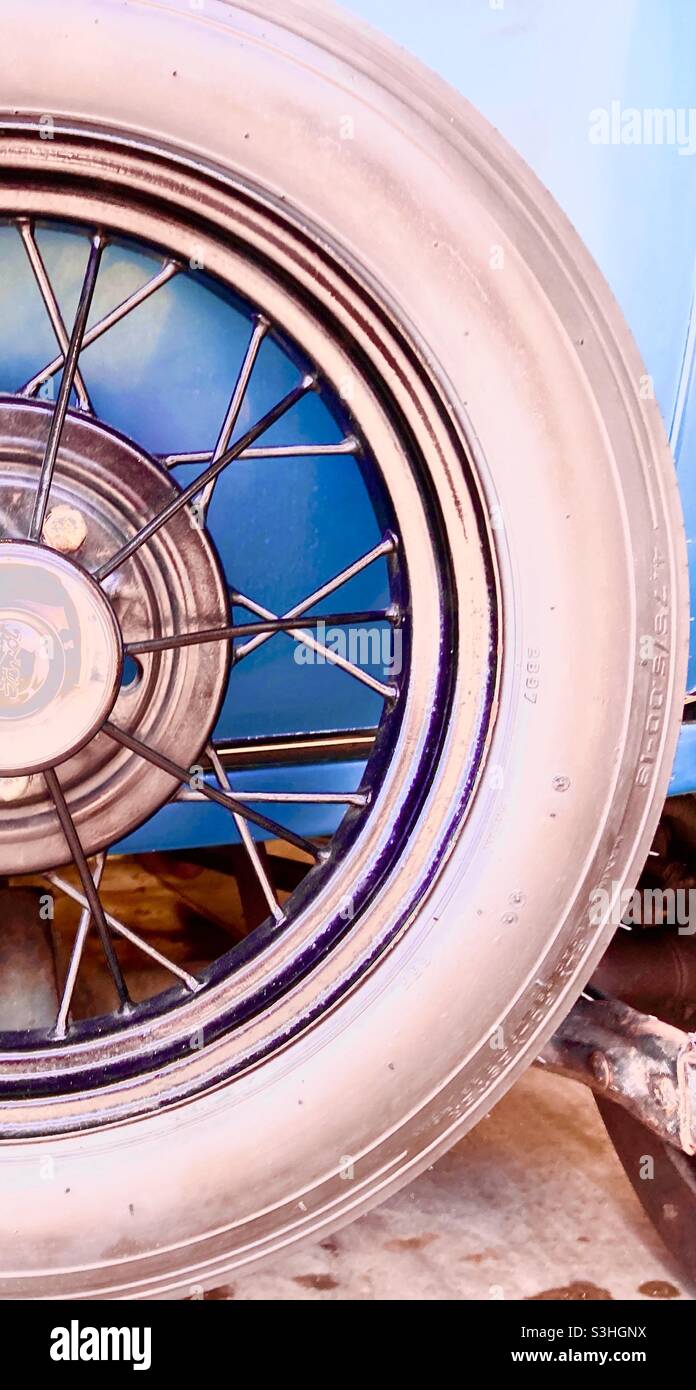 Half a wire spoked wheel on an antique car Stock Photo