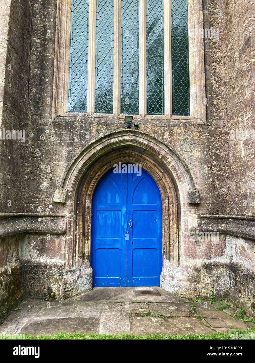 Chew magna church - blue door - st Michael’s church - North Somerset- church window Stock Photo