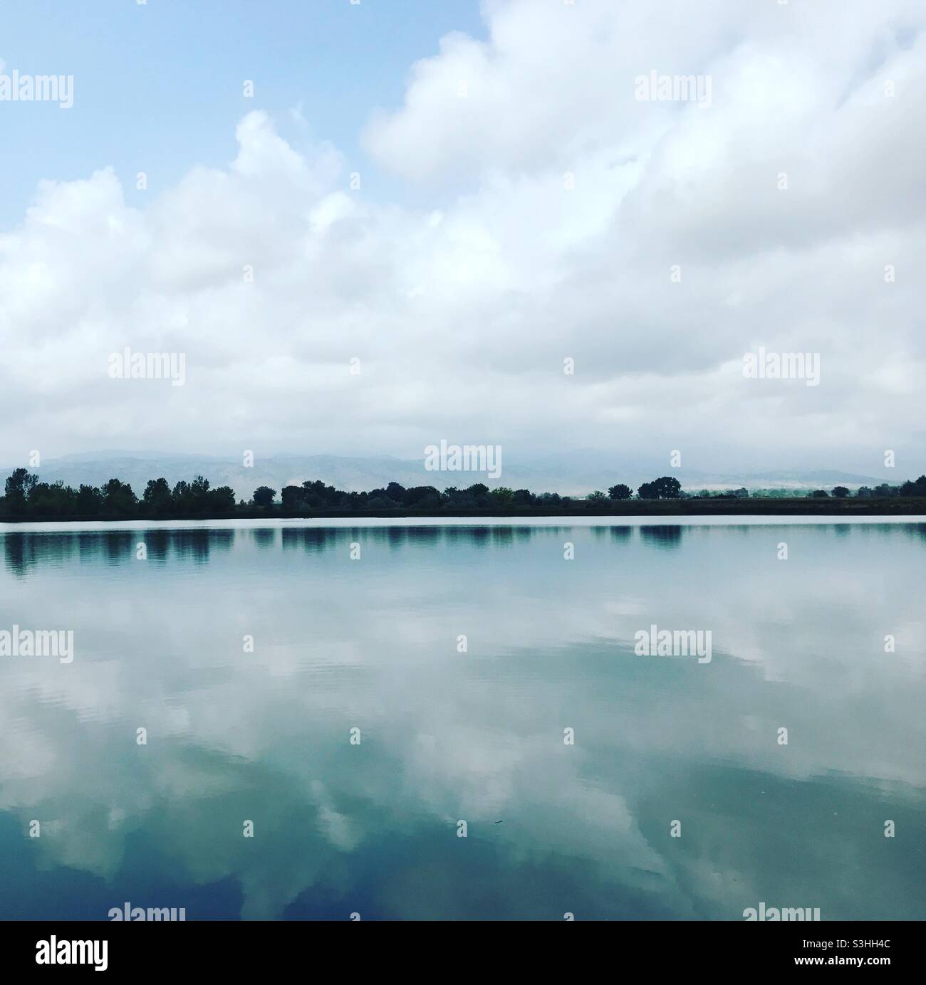 Yes it’s real! 100% perfectly mirrored sky on water Stock Photo