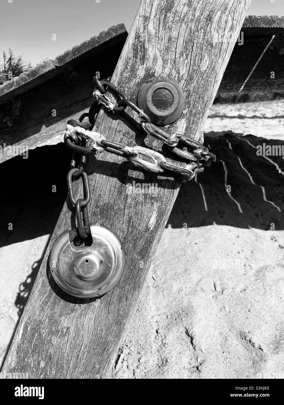 a steel chain is tied around a diagonal wooden post with a round