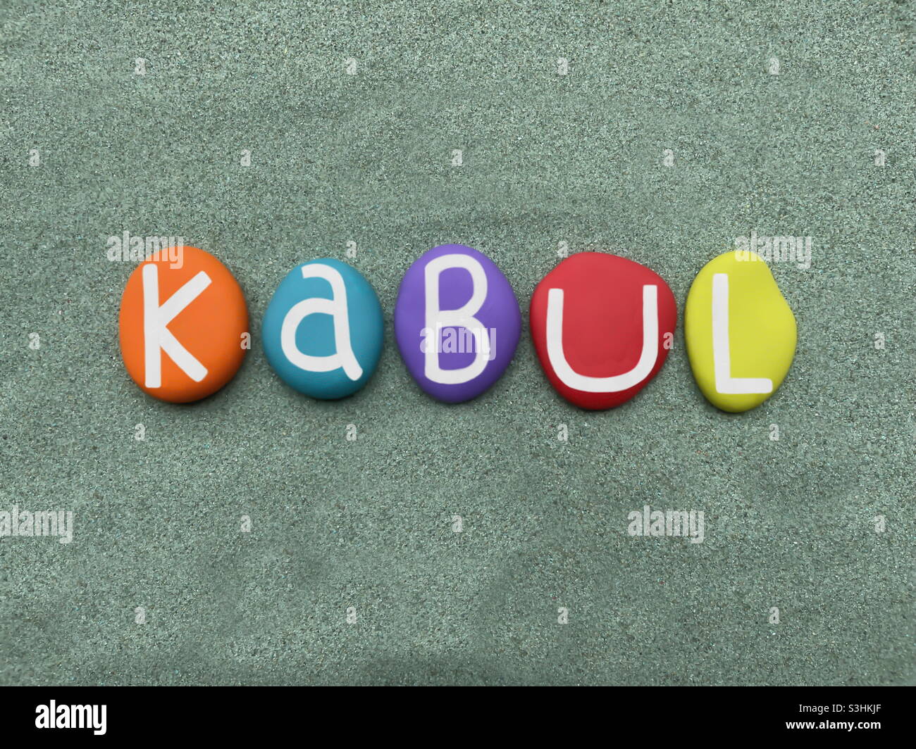 Kabul, capital of Afghanistan, souvenir composed with hand painted multi colored stone letters over green sand - Smartphone Captured Stock Image
