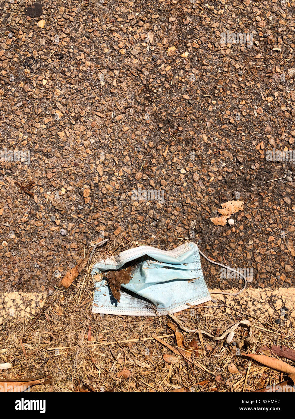 Disposable face mask on the roadside. Stock Photo