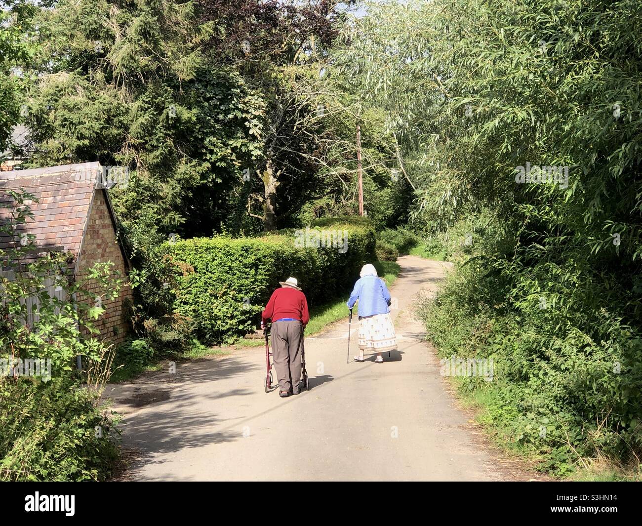 An aged couple stroll down a country lane in Oxfordshire, UK - Smartphone Captured Stock Image