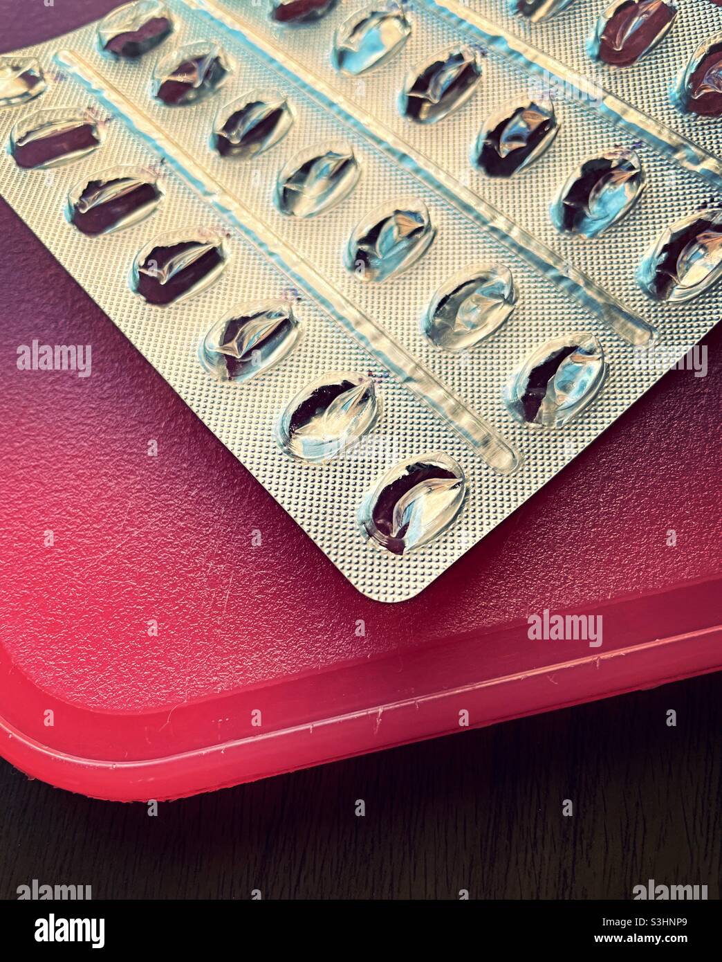 Still life of an used prescription pill blister pack on an orange cutting board. - Smartphone Captured Stock Image