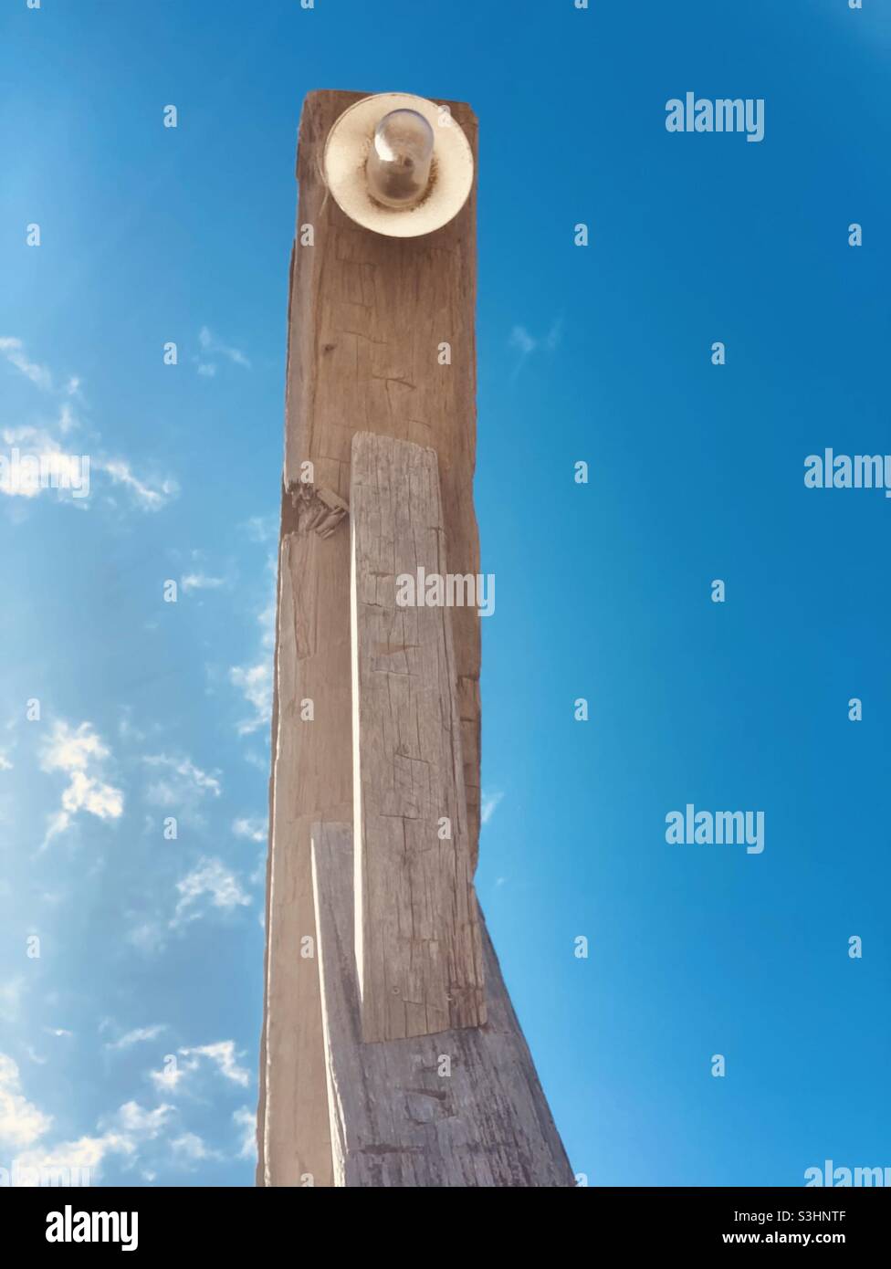 a lamp on a wooden frame upview to the blue sky - Smartphone Captured Stock Image