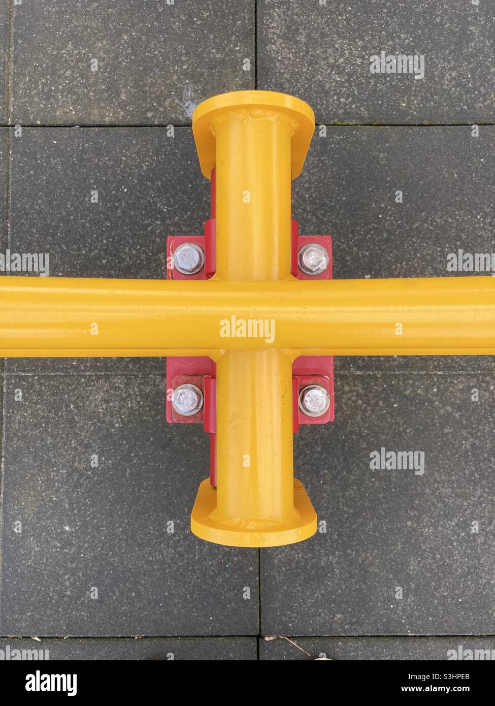 yellow tubes cross at right angles on a red console - Smartphone Captured Stock Image