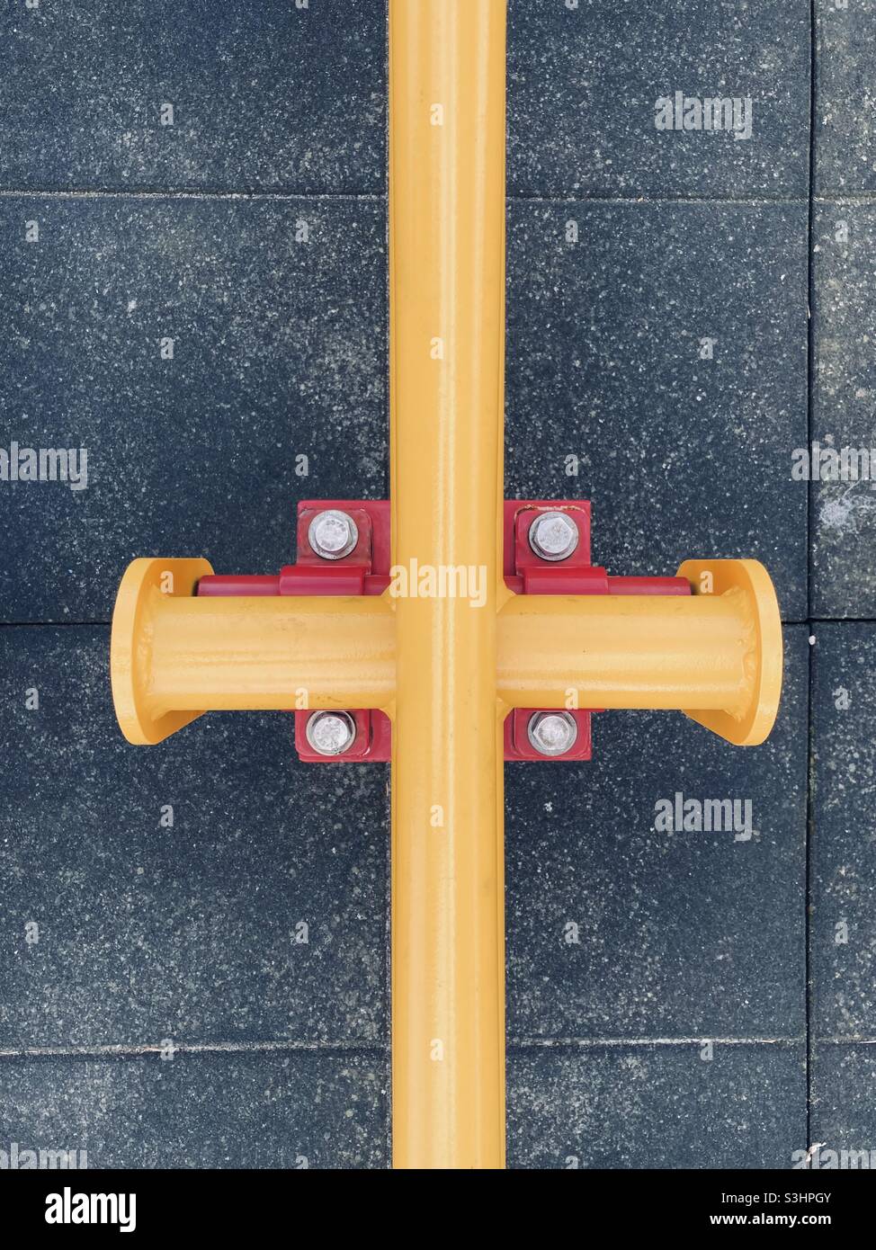 yellow tubes cross at right angles on a red console - Smartphone Captured Stock Image