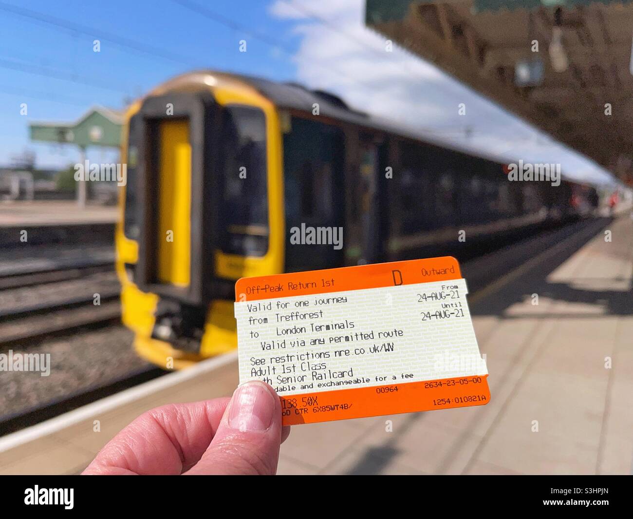Closeup view of a rail ticket with a train in the background Stock Photo