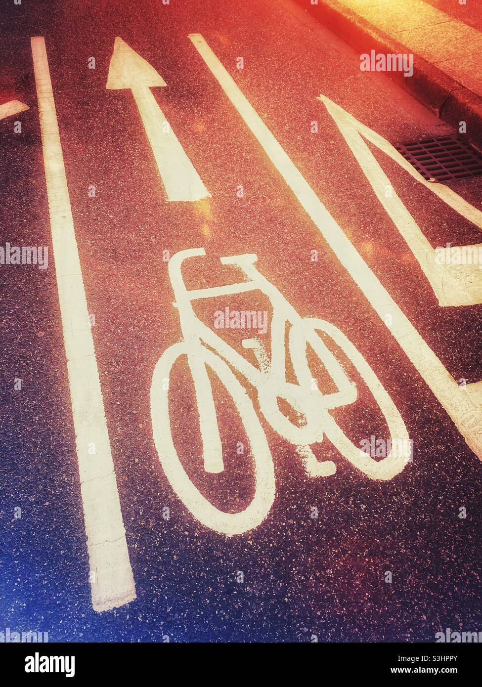 A colourful image of the road markings that indicate a cycle lane is ahead and can be used by cyclists going forward. The other lane indicates cyclists should stop. Photo ©️ COLIN HOSKINS. - Smartphone Captured Stock Image