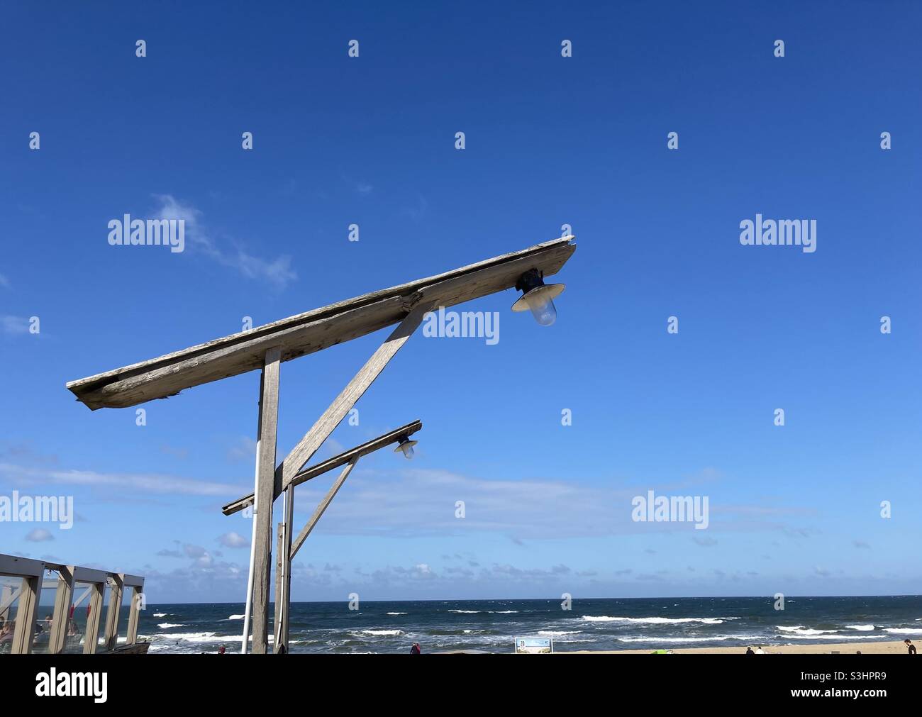 Two lamps with wooden frames on the beach with blue sky in the background Stock Photo