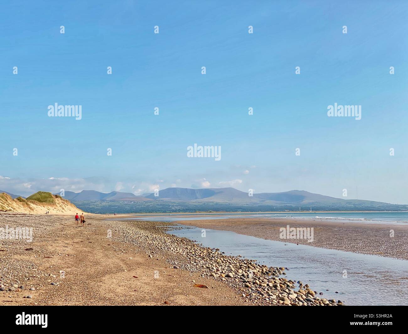 Seaside coast off Newborough Warren, Anglesey, north wales, uk, with Snowdonia mountain range in the distance, late summer, august 2021 - Smartphone Captured Stock Image