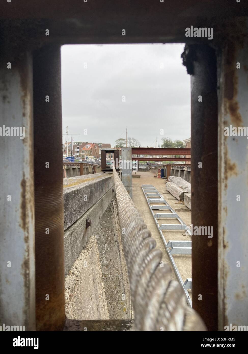 Tensioned Steel Rope through a Window in an Harbor Environment - Smartphone Captured Stock Image