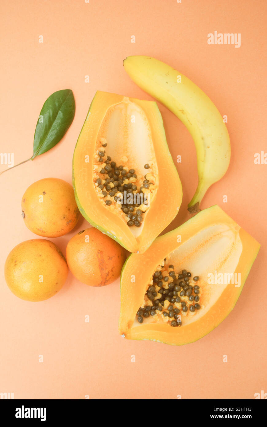 Papaya, banana and oranges in a orange background Stock Photo Alamy