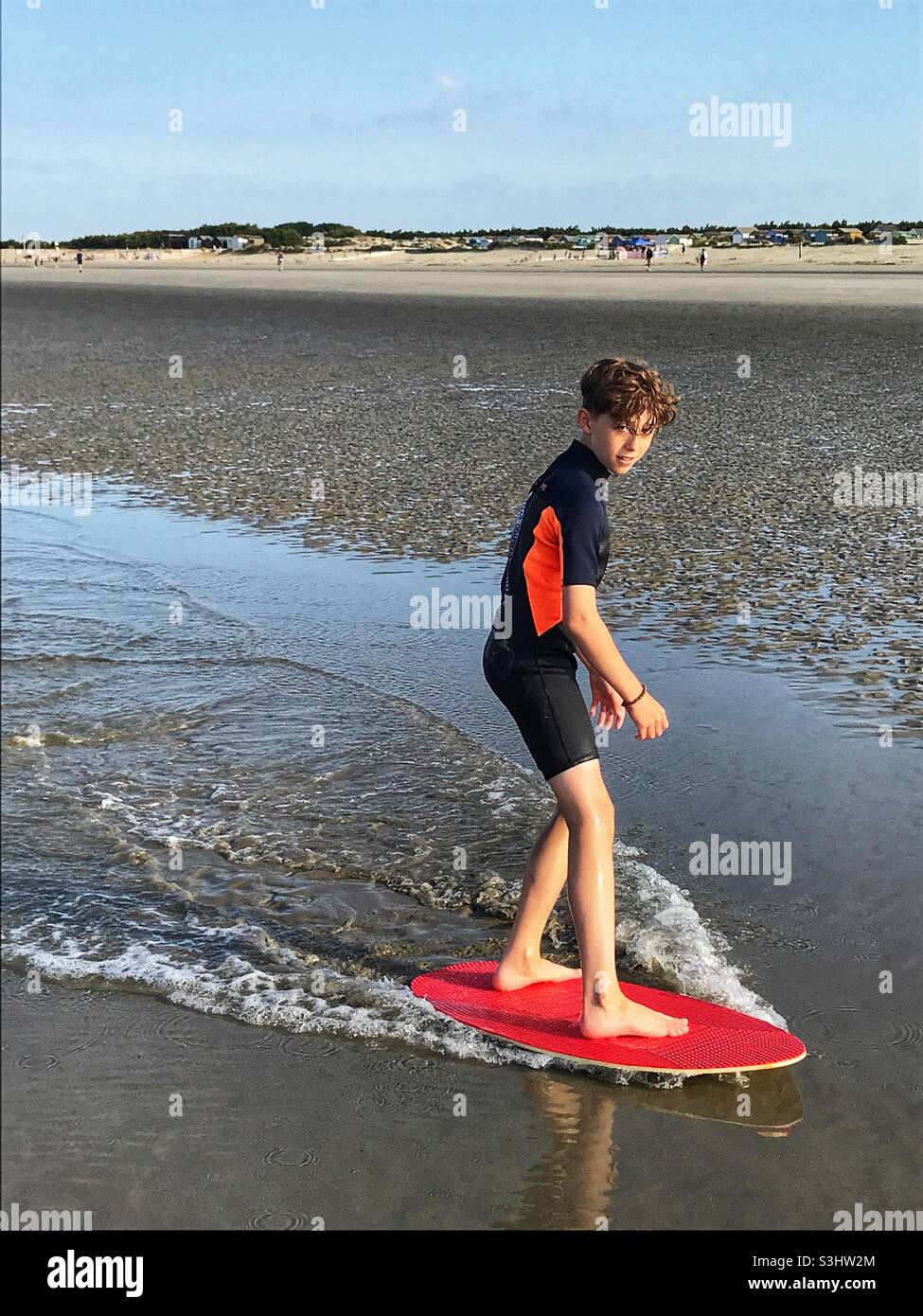 Twelve year old boy on a skimboard West Wittering beach, England. Stock Photo