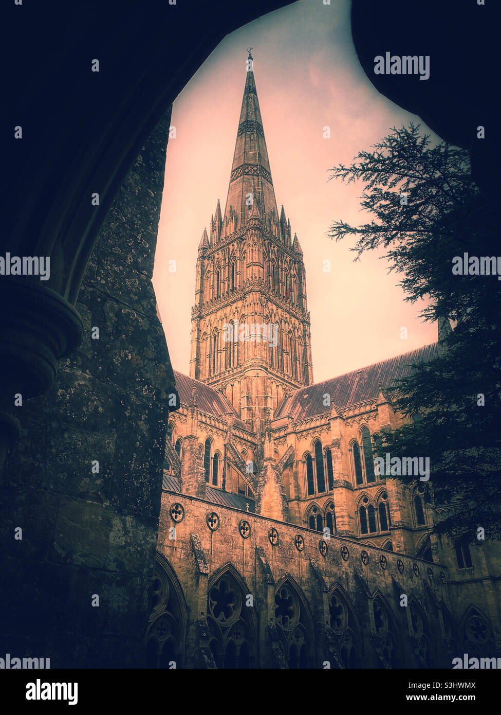 A creative view of the world famous Spire of Salisbury Cathedral, Wiltshire, England. This view is from the large Cathedral Cloisters. The Spire is the tallest in the UK at 123 metres. Photo ©️ CH. - Smartphone Captured Stock Image