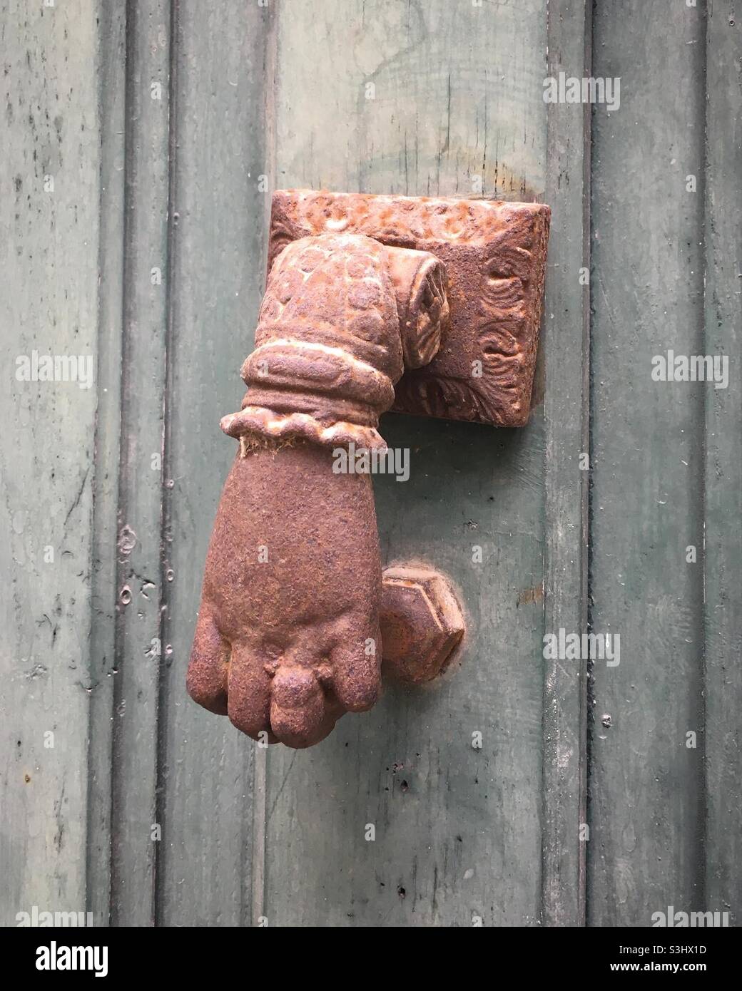 Old door knocker in the shape of a hand Stock Photo