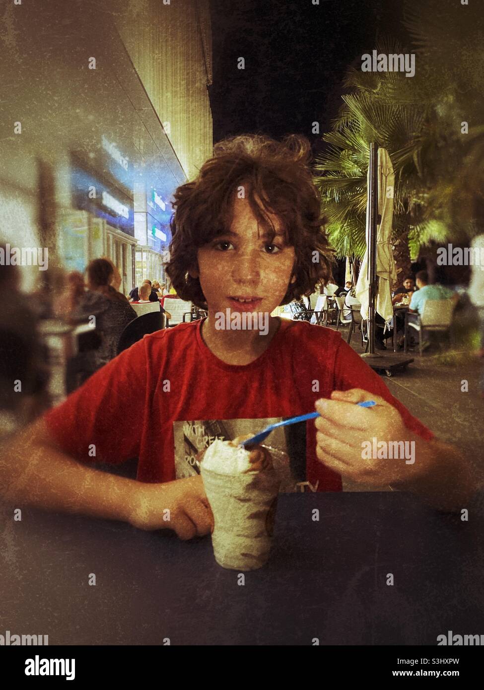 Beautiful eleven years boy eating ice cream cup at the Icecream shop