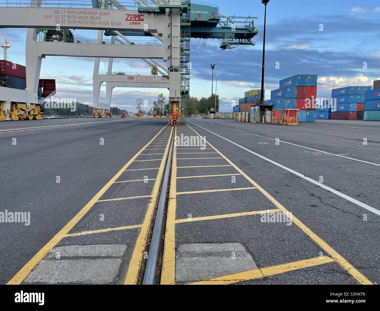 Steel rail of the gantry crane in Portland, Oregon USA container terminal ready for cargo loading operation to moored vessel. Stock Photo