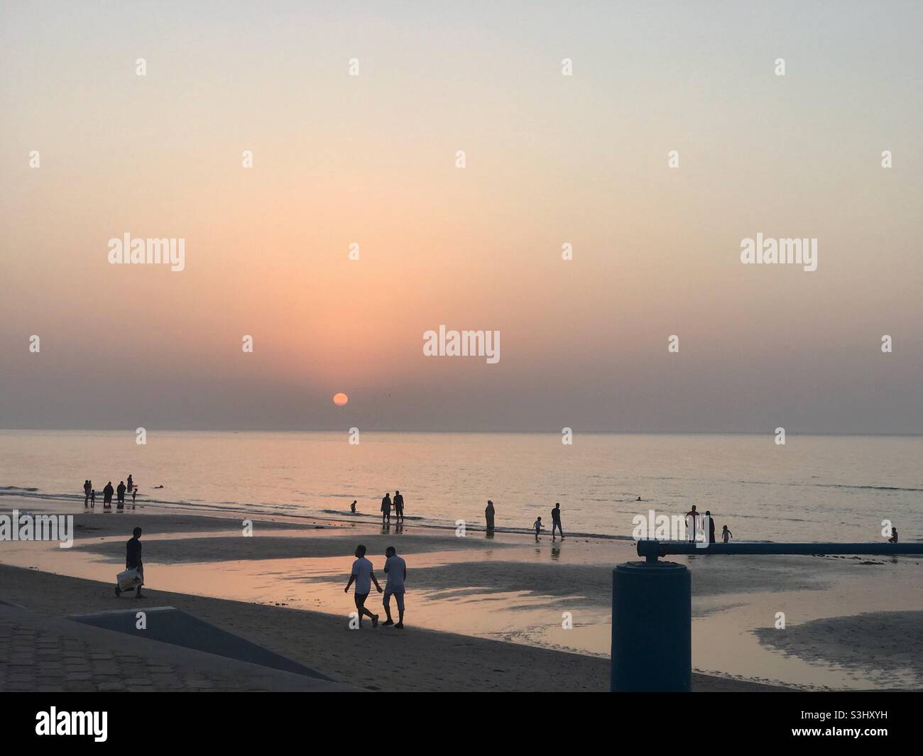 Sunset walk: favorite time by the locals of Muscat, Oman to b outdoors especially the beach. With families lies and friends walking together. - Smartphone Captured Stock Image