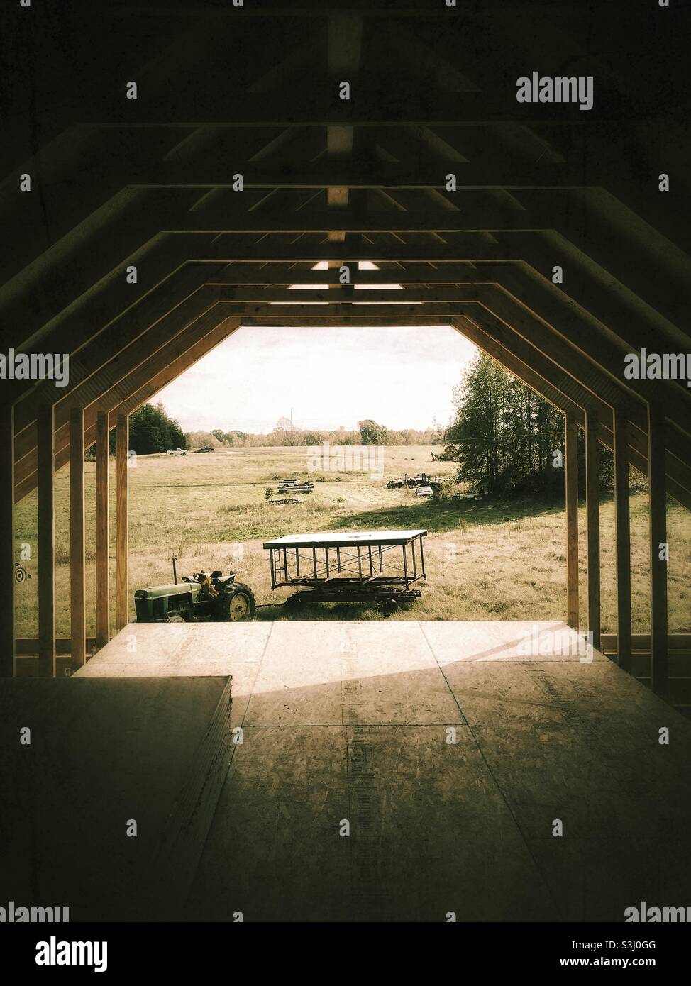 View from open side of unfinished house’s attic across farm field - Smartphone Captured Stock Image