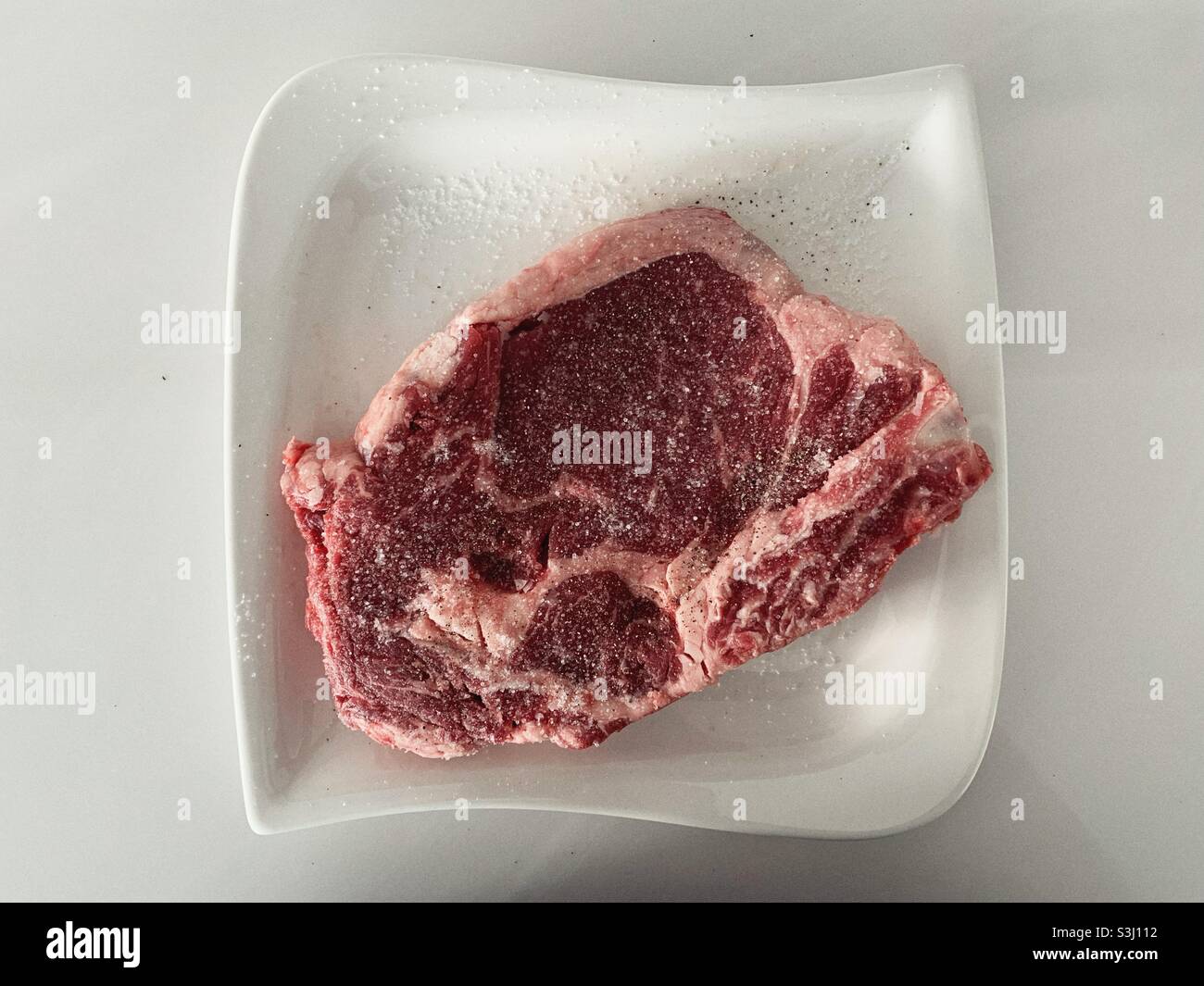 Salted raw rib eye steak Stock Photo Alamy