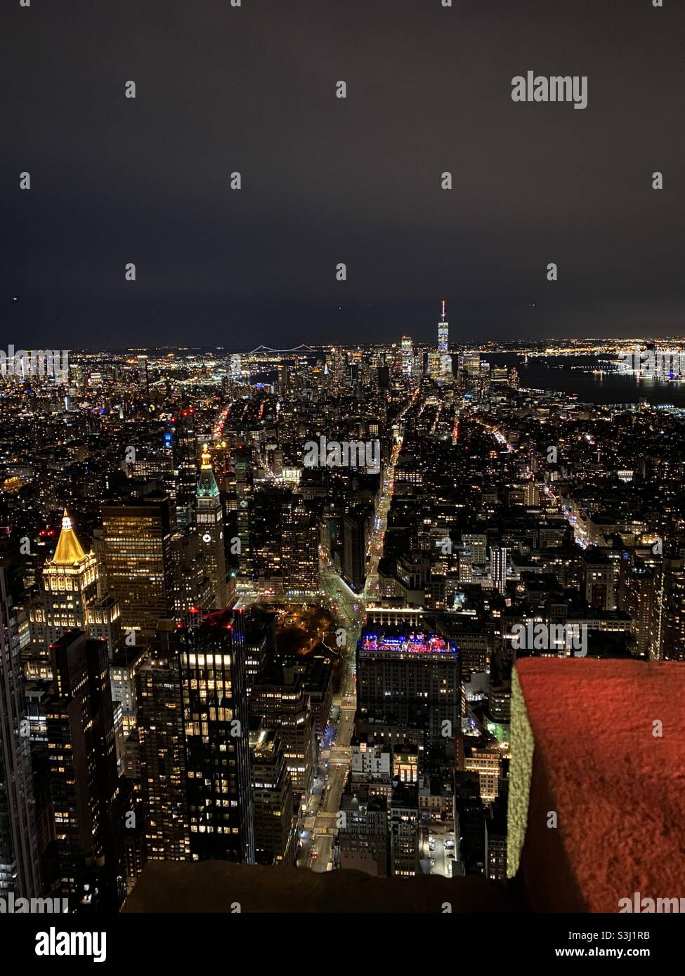 New York by night with Hudson River and Statue of Liberty in the distance. Taken from the Empire State Building in December 2019 - Smartphone Captured Stock Image