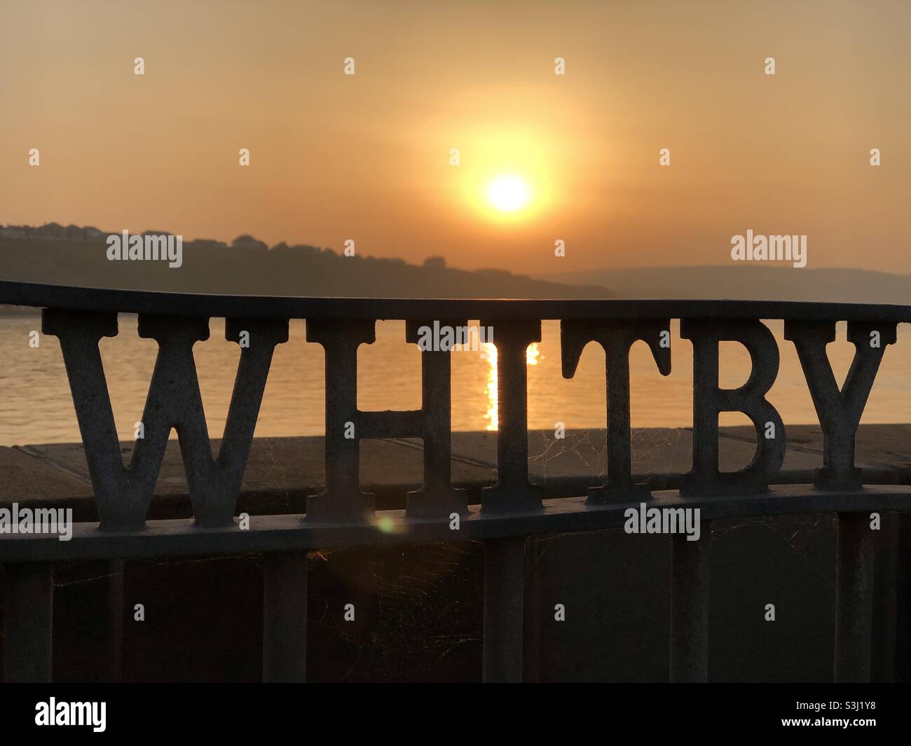 Sunset at Whitby behind metal gate - Smartphone Captured Stock Image