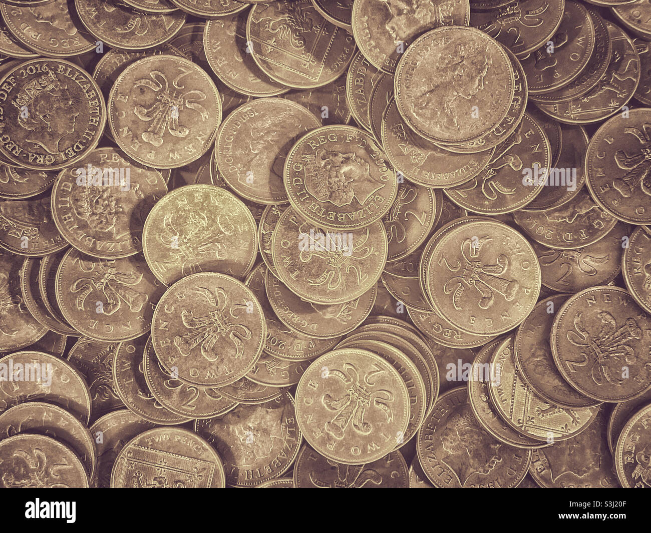 Looking down on a pile of British 2 pence coins. A common sight in slot machines at amusement arcades. Queen Elizabeth’s portrait features on the coin. Photo ©️ COLIN HOSKINS. - Smartphone Captured Stock Image