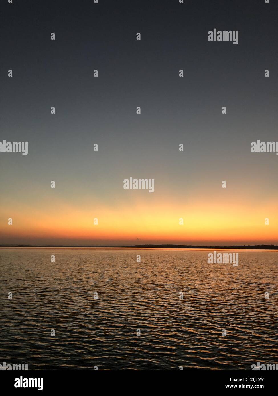 Sunset over water Stock Photo - Alamy