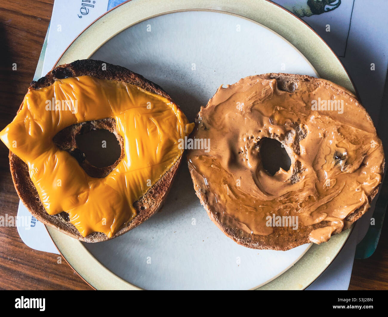 Bagels on a plate with cheese and peanut butter. - Smartphone Captured Stock Image
