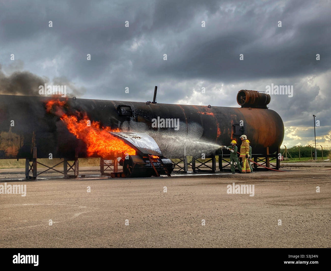 Fire fighters practicing on a aircraft simulator - Smartphone Captured Stock Image