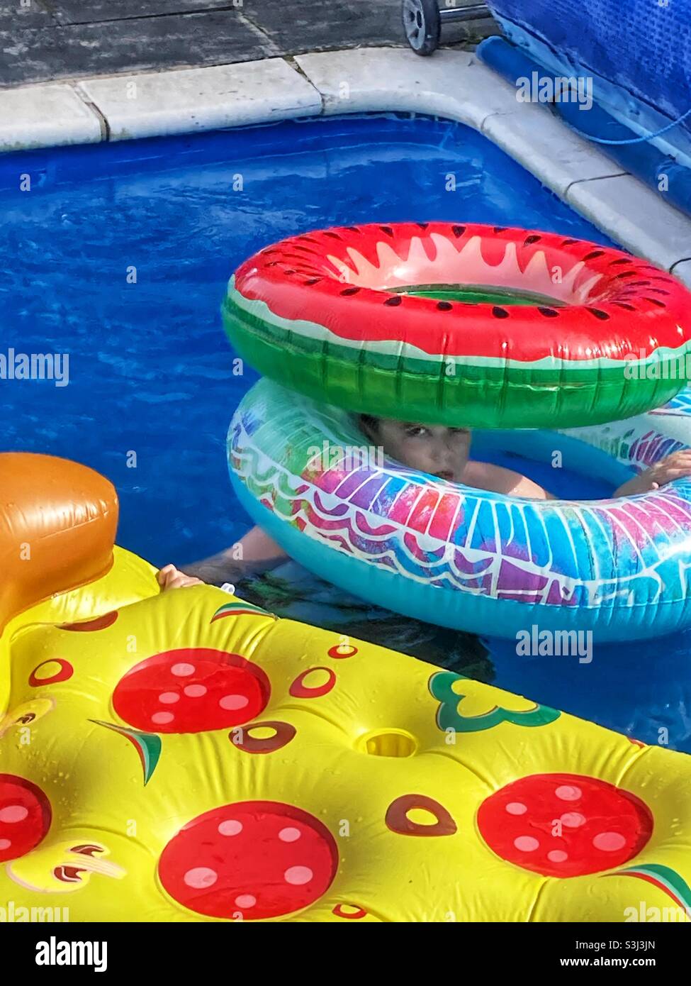 Boy playing with inflatables in a swimming pool Stock Photo Alamy