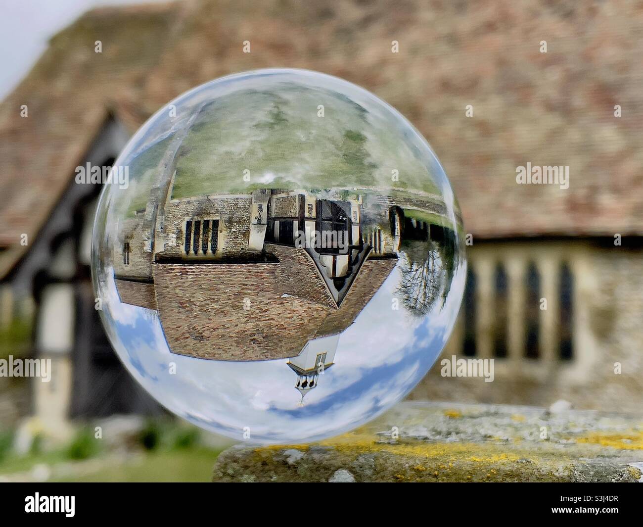 St Simon and St Jude church, Quendon, Essex UK through a glass ball Stock Photo