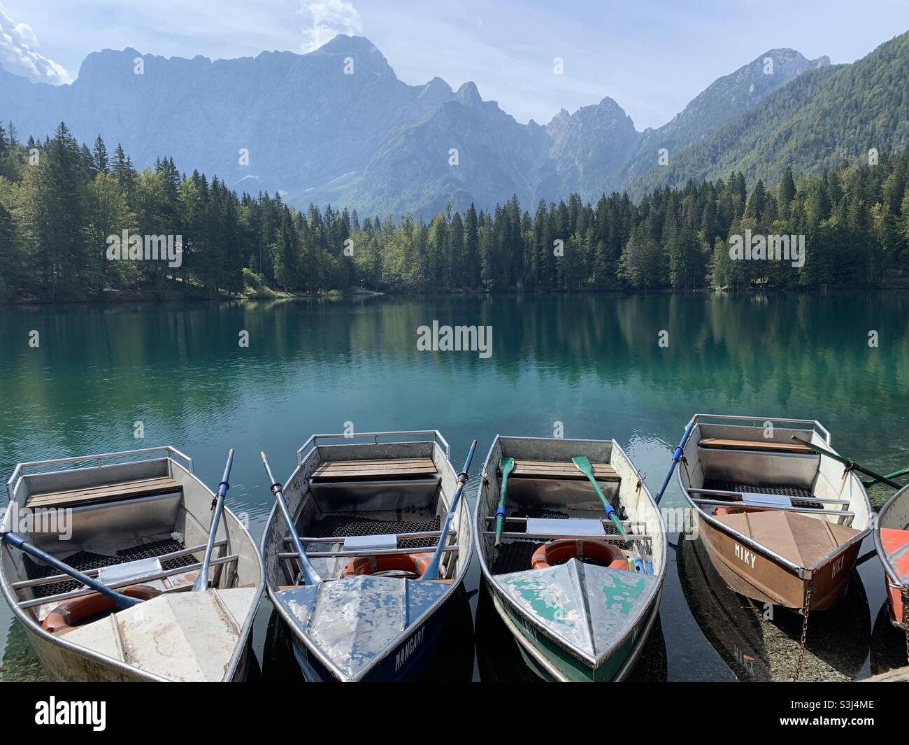 Metal row boats on lake fuzine Italy Stock Photo