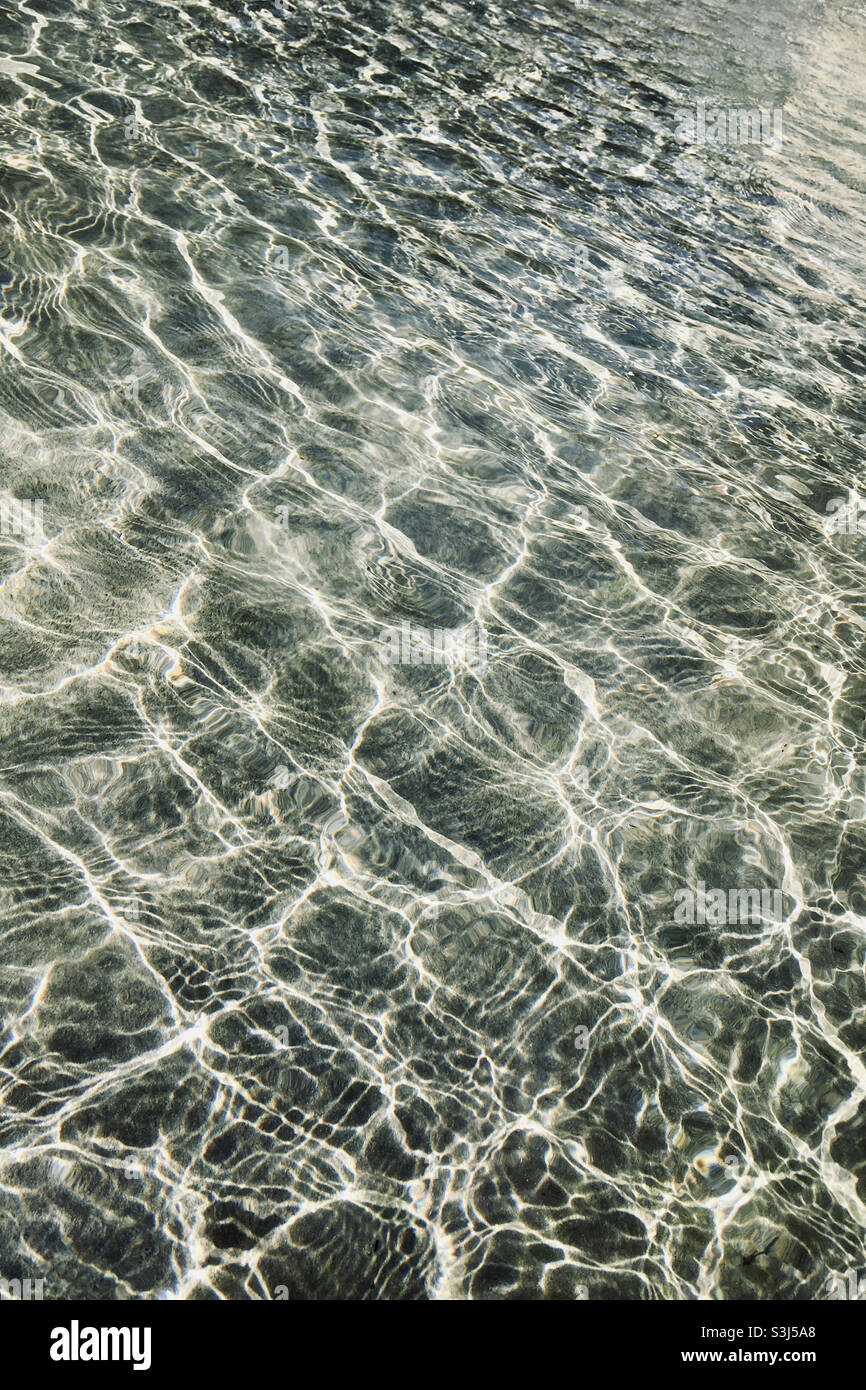 Waves of water in pool with sunlight glittering on surface - Smartphone Captured Stock Image